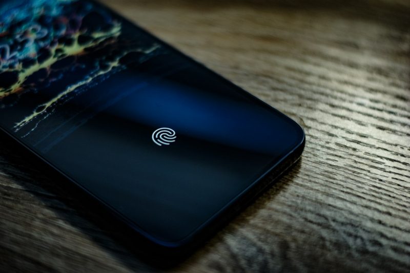 Smartphone dengan fitur autentikasi sidik jari untuk menggambarkan teknologi passkeys dan keamanan login